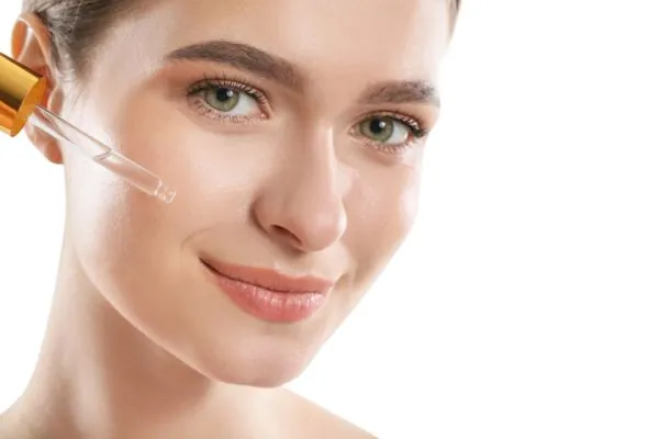 Smiling woman applying anti-aging serum near her smile lines